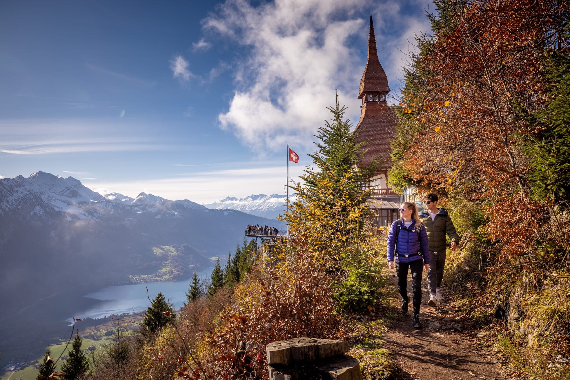 Walkers on a path at Harder Kulm with the lookout platform and lake below