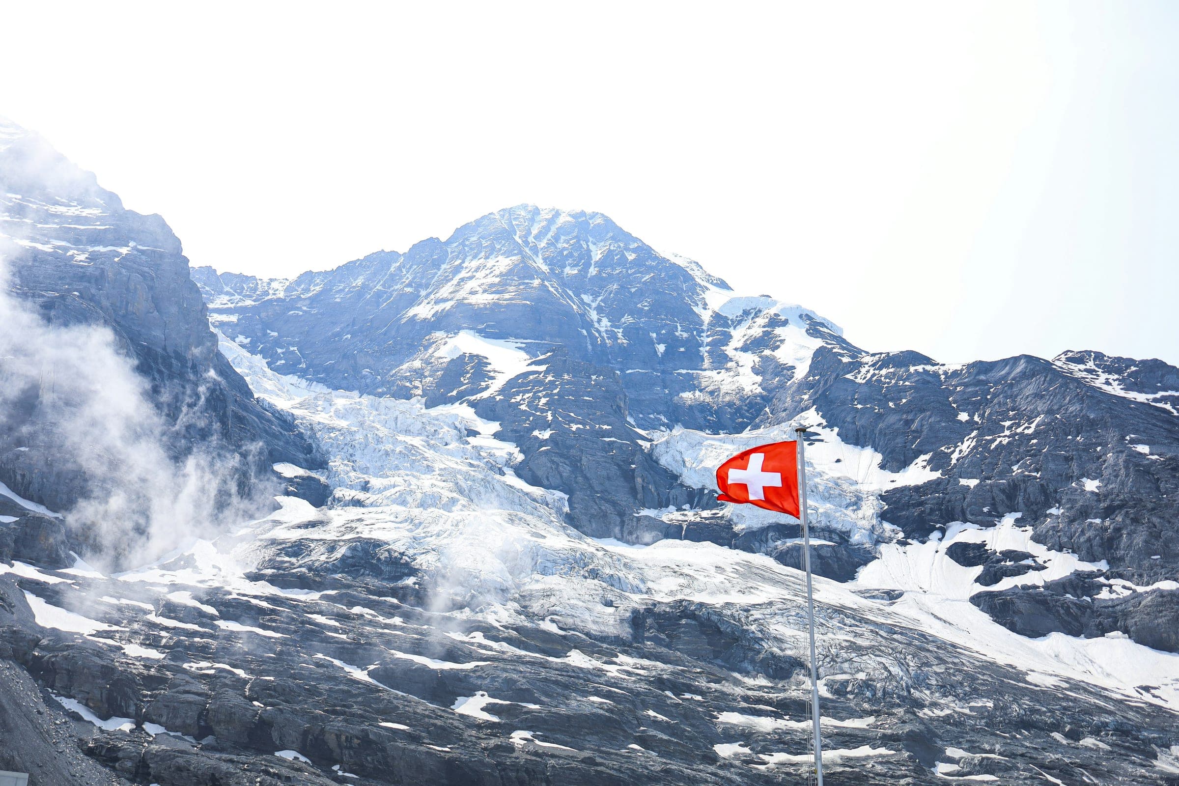 Snow-covered Eiger glacier with a Swiss flag on the way to Jungfraujoch