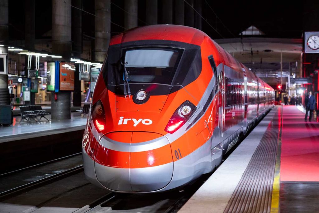 İspanya'da istasyonda bekleyen kırmızı IRYO hızlı treni. Sürdürülebilir ve modern Avrupa içi tren seyahati.